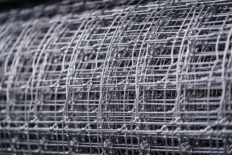 Detailed view of a rolled metal wire mesh, highlighting intricate patterns and textures.